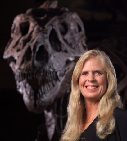 photo of Sue Hendrickson next to a dinosaur fossil