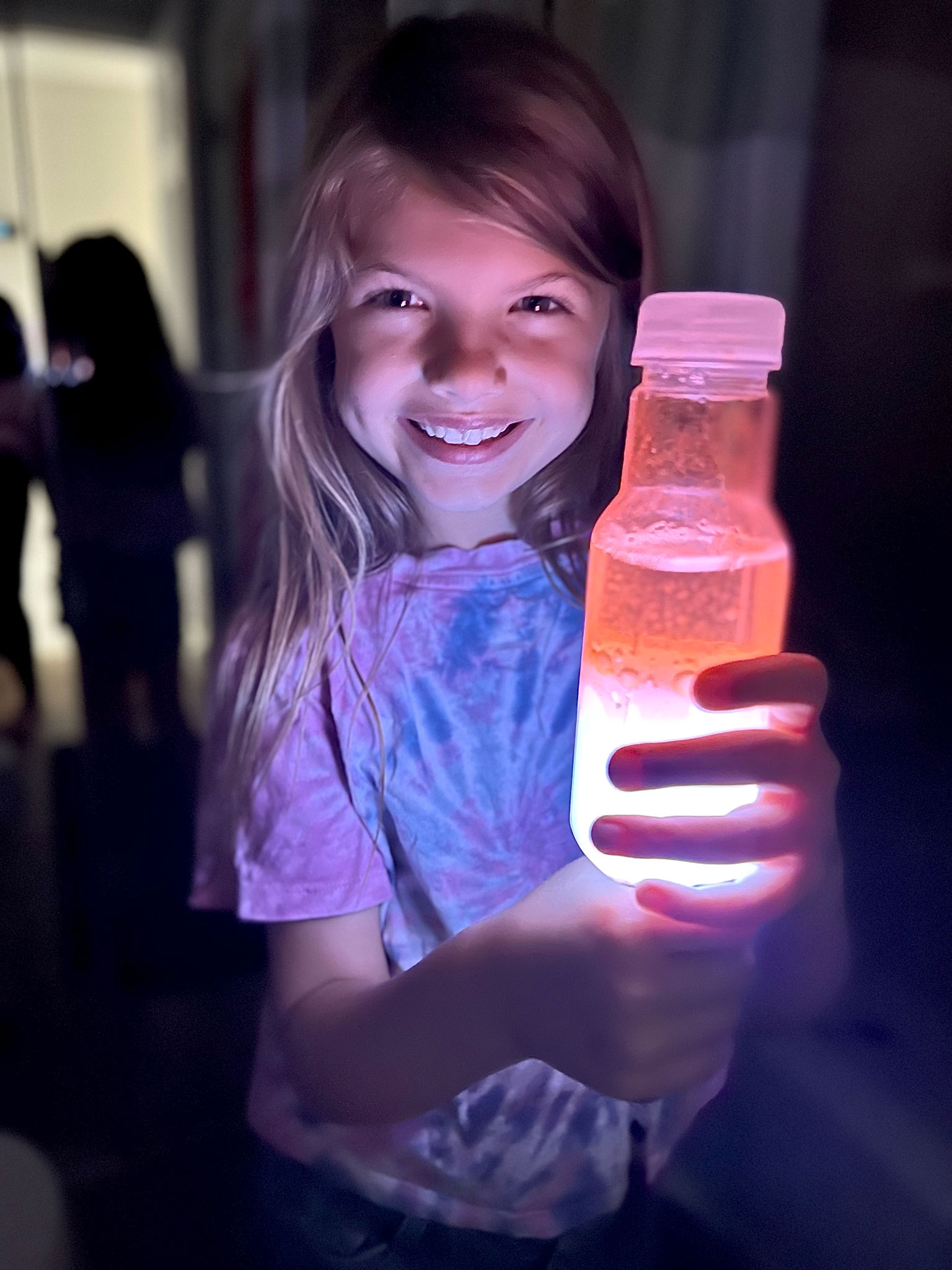 girl holding a glow in the dark bottle